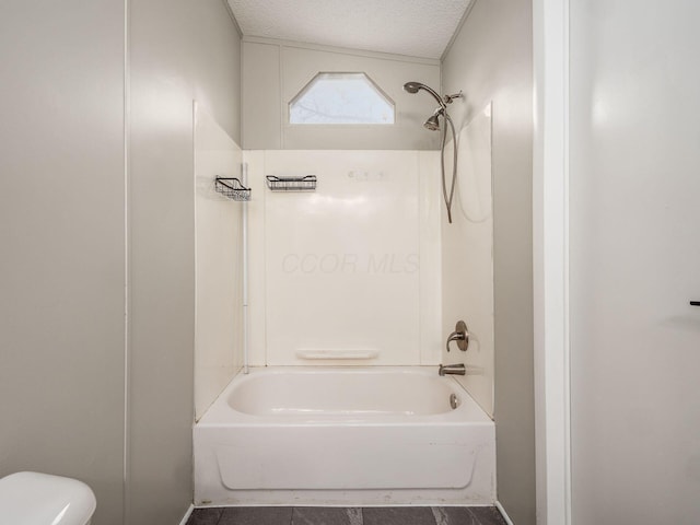 bathroom with toilet, shower / bath combination, and a textured ceiling