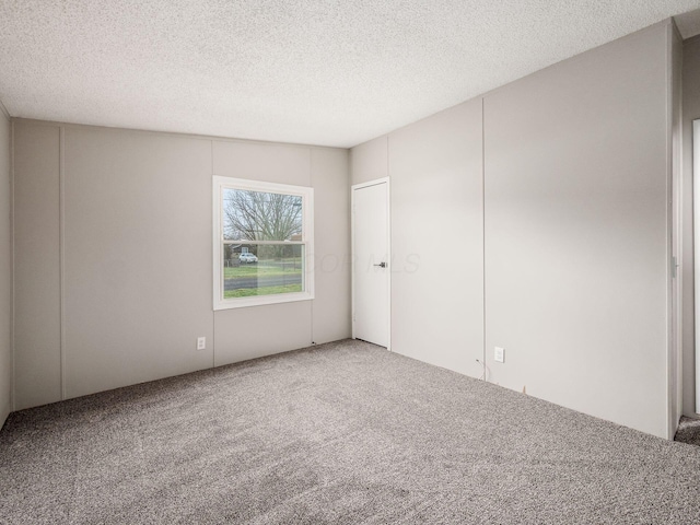 spare room featuring a textured ceiling and carpet floors