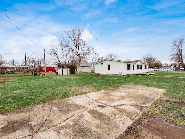 view of yard with a storage unit and a patio