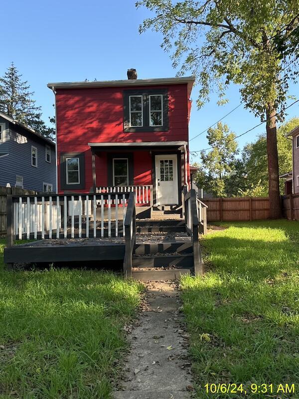 rear view of house with a wooden deck and a yard