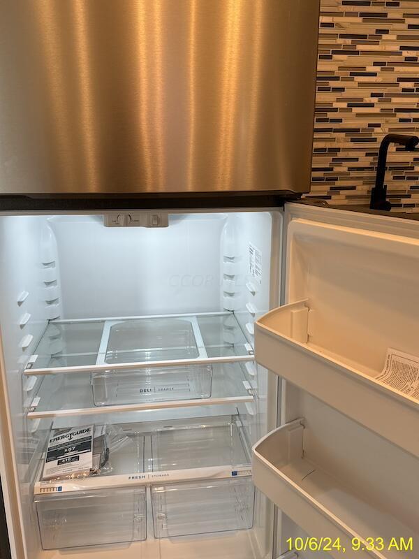 interior details featuring tasteful backsplash and stainless steel refrigerator