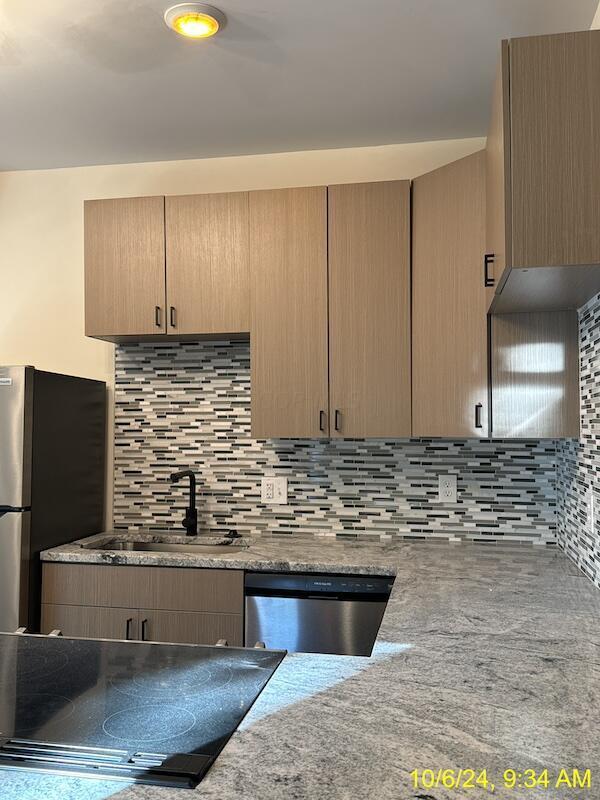 kitchen with light brown cabinetry, decorative backsplash, sink, and stainless steel appliances