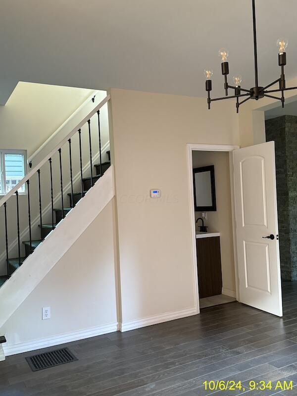 stairs featuring hardwood / wood-style flooring and a notable chandelier