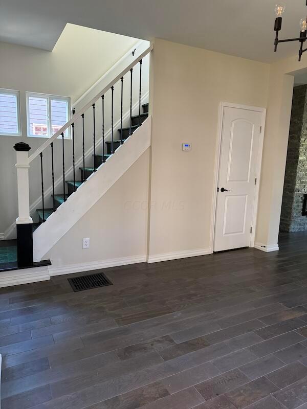 stairs featuring hardwood / wood-style floors and a chandelier