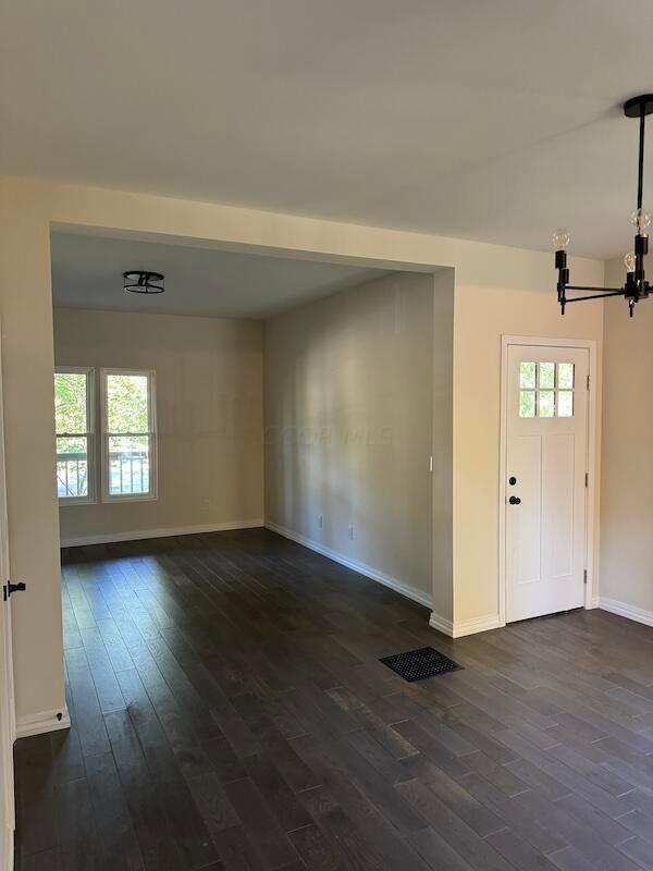 foyer entrance featuring a chandelier, dark hardwood / wood-style flooring, and a wealth of natural light