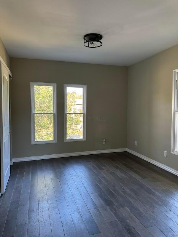 unfurnished room with dark hardwood / wood-style floors