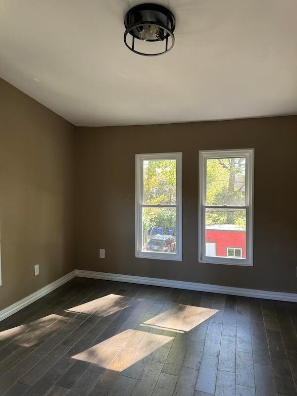 spare room with dark wood-type flooring