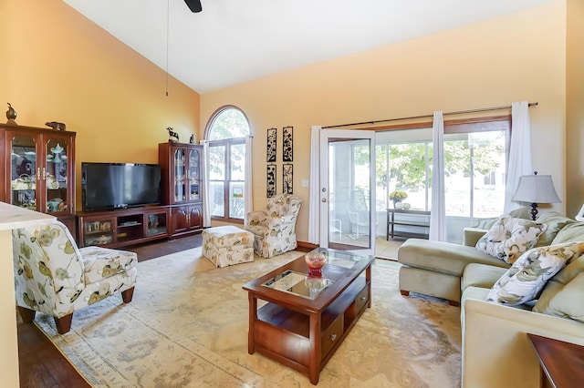 living room featuring light wood-type flooring, high vaulted ceiling, and ceiling fan