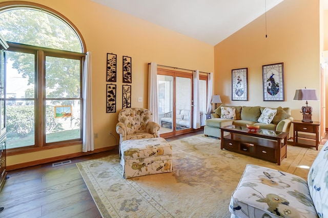 living room featuring light wood-type flooring and high vaulted ceiling