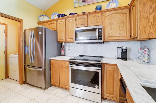 kitchen featuring appliances with stainless steel finishes, tasteful backsplash, lofted ceiling, and light tile patterned flooring