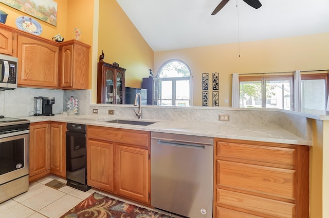 kitchen featuring appliances with stainless steel finishes, tasteful backsplash, ceiling fan, sink, and lofted ceiling