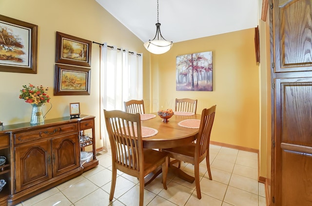 dining room with light tile patterned floors and vaulted ceiling