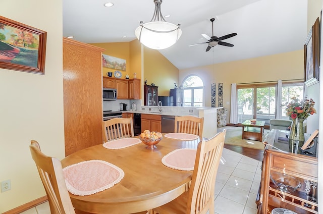 dining room with ceiling fan, light wood-type flooring, lofted ceiling, and sink