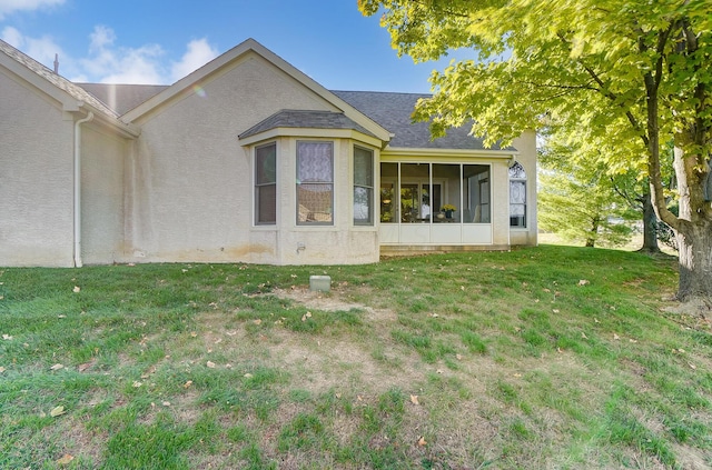 back of house with a lawn and a sunroom