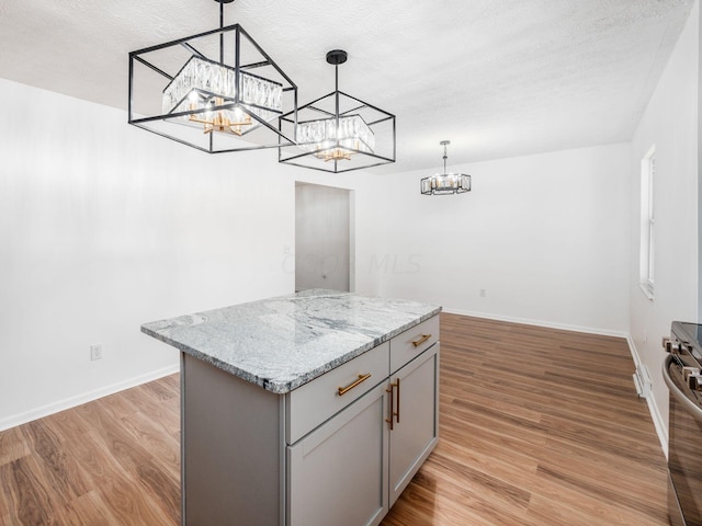 kitchen with pendant lighting, a center island, gray cabinets, and light wood-type flooring