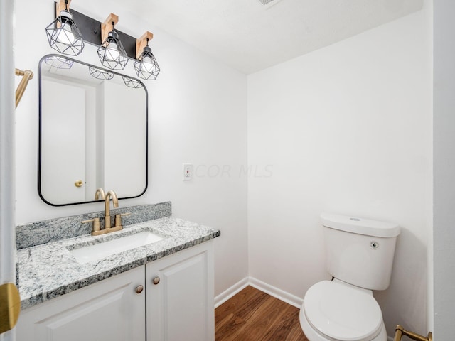 bathroom featuring hardwood / wood-style floors, vanity, and toilet