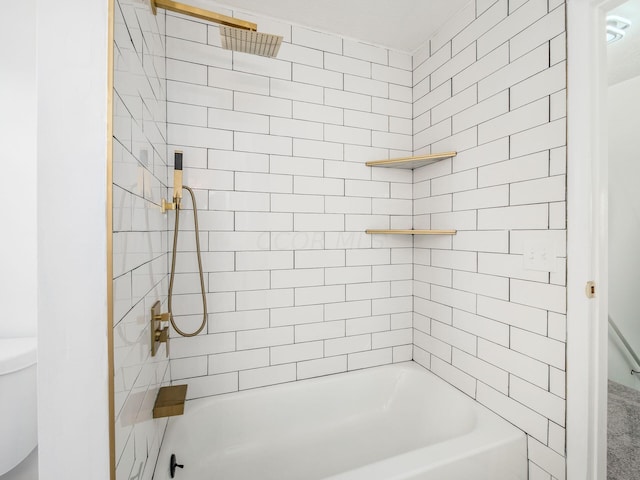 bathroom featuring tiled shower / bath combo and toilet