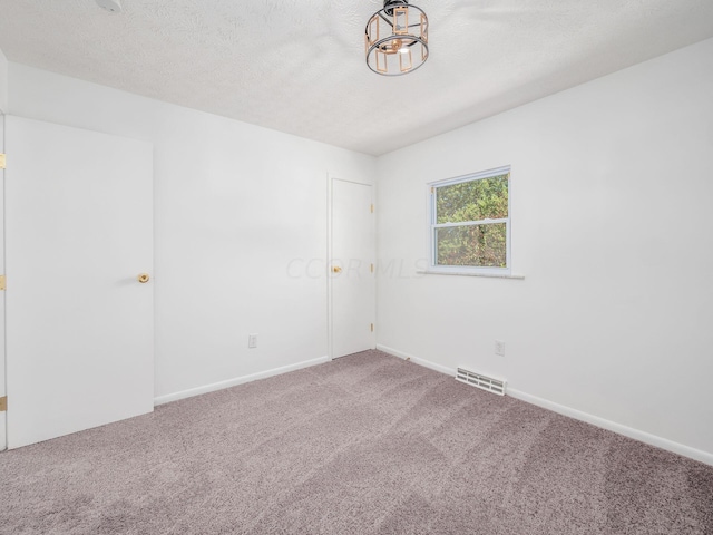 empty room featuring carpet flooring and a textured ceiling