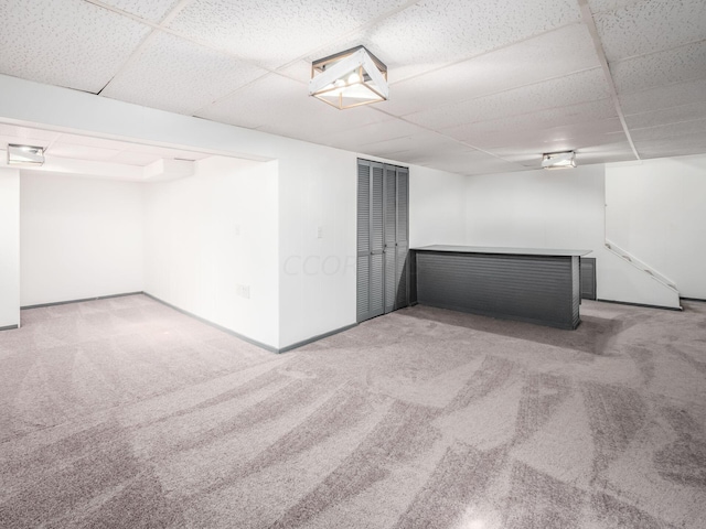 basement featuring carpet and a drop ceiling