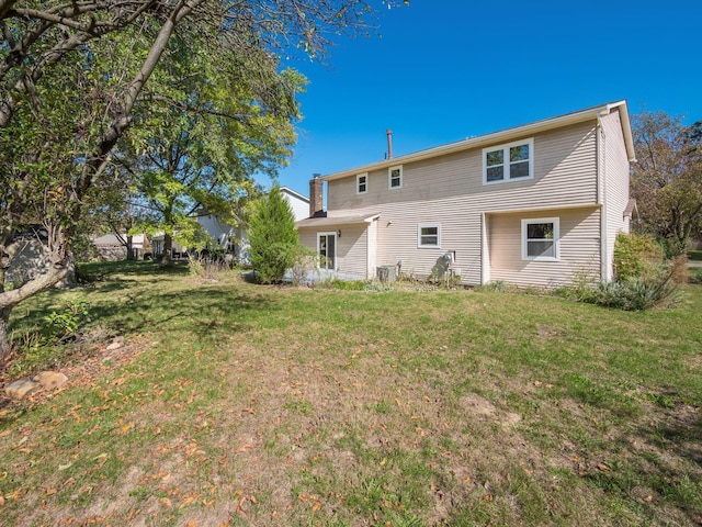 rear view of house featuring a lawn