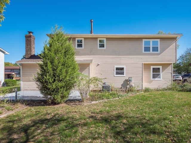 rear view of property featuring a lawn