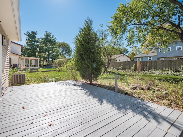 wooden deck with a sunroom and cooling unit