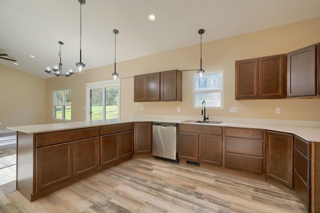 kitchen with kitchen peninsula, dishwasher, pendant lighting, and light wood-type flooring