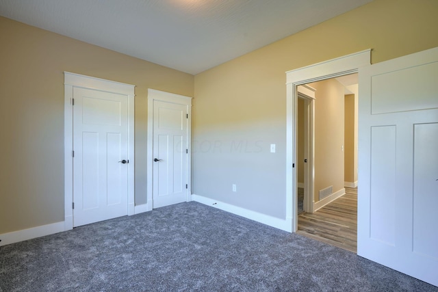 unfurnished bedroom featuring dark colored carpet