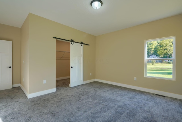 unfurnished bedroom with a walk in closet, carpet floors, and a closet