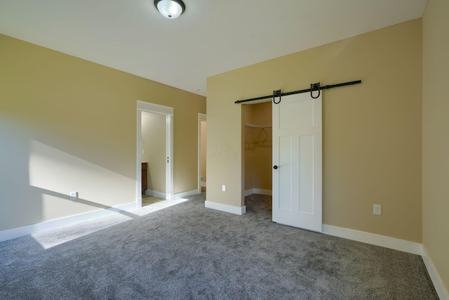 32360 Redbud Ln, Logan, OH 43138 - unfurnished bedroom with a barn door, carpet floors, a walk in closet, and a closet
