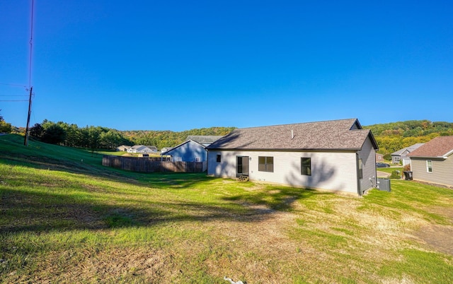 rear view of property with a yard and central AC