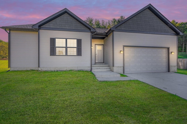 ranch-style home featuring a garage and a yard