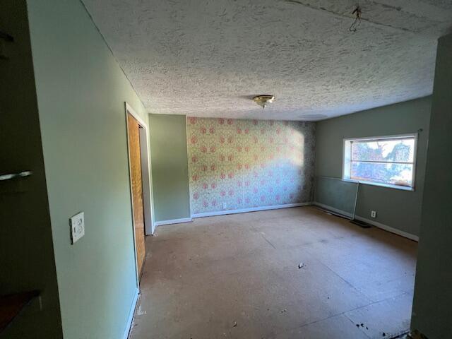 unfurnished room with a textured ceiling