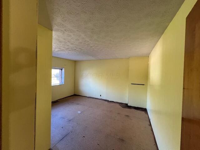 unfurnished room featuring a textured ceiling