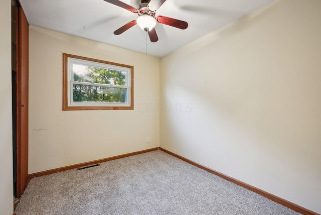 spare room featuring carpet floors and ceiling fan