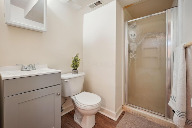 bathroom with wood-type flooring, vanity, toilet, and walk in shower