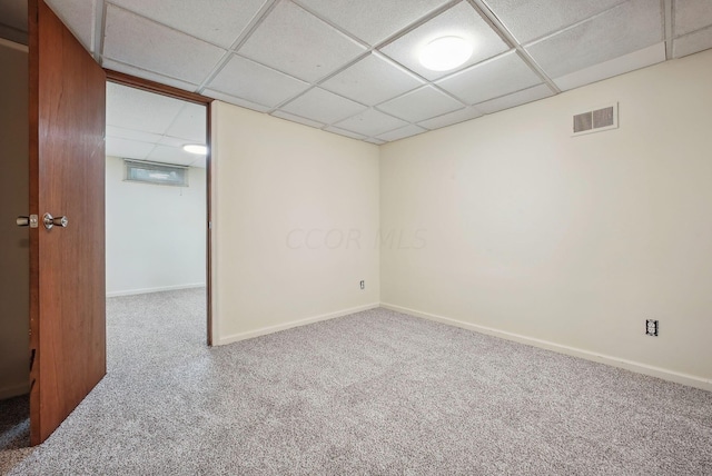 carpeted spare room with a drop ceiling