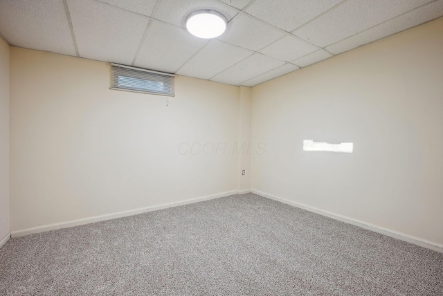 basement with a paneled ceiling and carpet floors