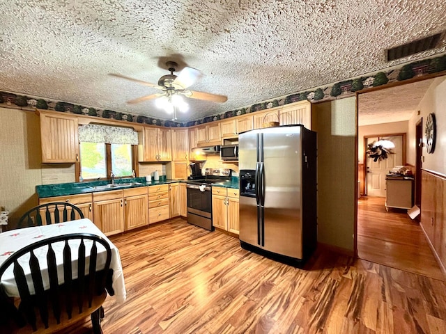 kitchen featuring a textured ceiling, stainless steel appliances, light hardwood / wood-style flooring, and sink