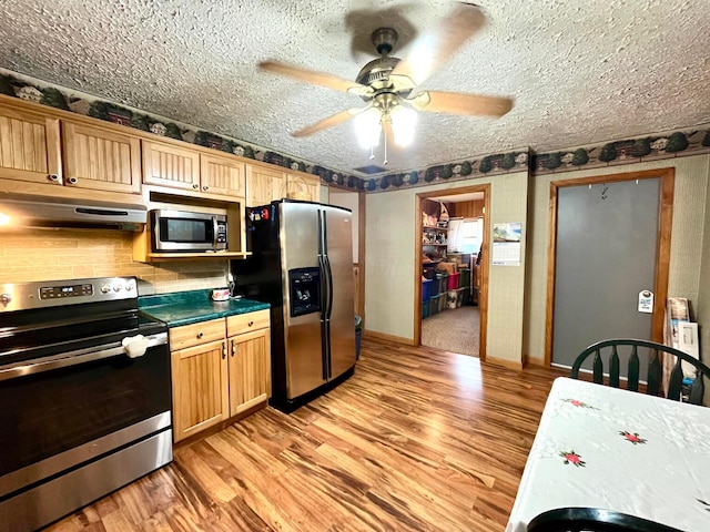 kitchen featuring appliances with stainless steel finishes, a textured ceiling, light hardwood / wood-style floors, and ceiling fan