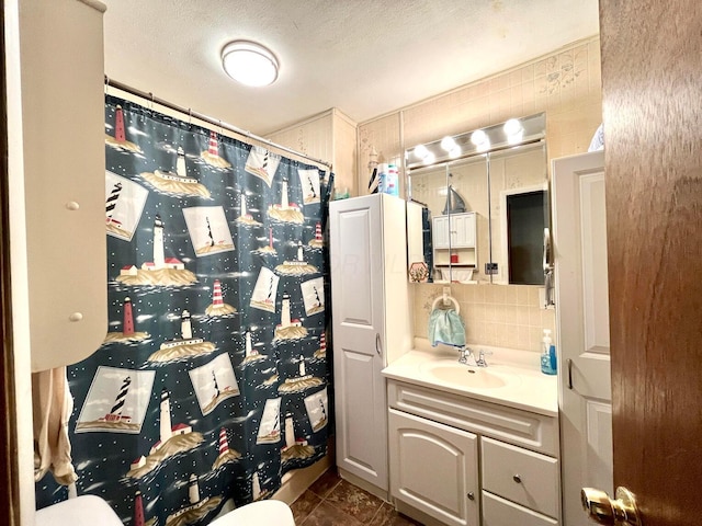 bathroom featuring vanity, curtained shower, decorative backsplash, and a textured ceiling