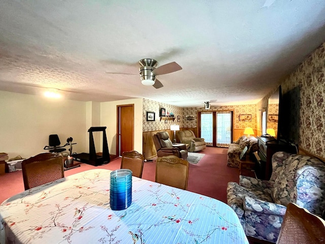 carpeted dining area with french doors, a textured ceiling, and ceiling fan