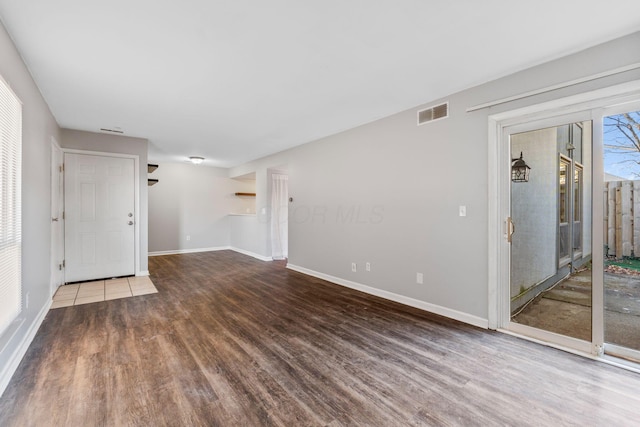 unfurnished living room with dark hardwood / wood-style flooring