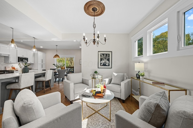 living room with a chandelier, a wealth of natural light, and dark wood-type flooring