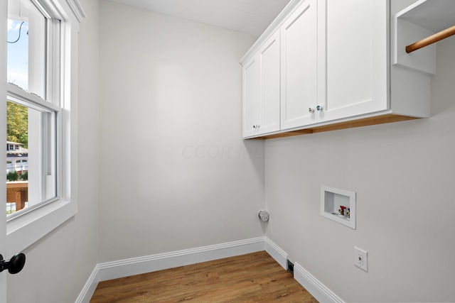 laundry area with cabinets, washer hookup, and light hardwood / wood-style flooring