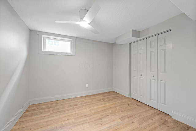 basement with ceiling fan and light hardwood / wood-style floors