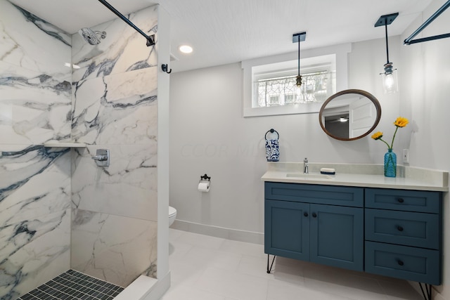 bathroom with vanity, toilet, and a tile shower