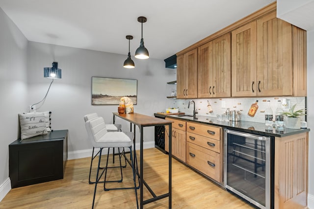 bar featuring light wood-type flooring, tasteful backsplash, beverage cooler, and sink