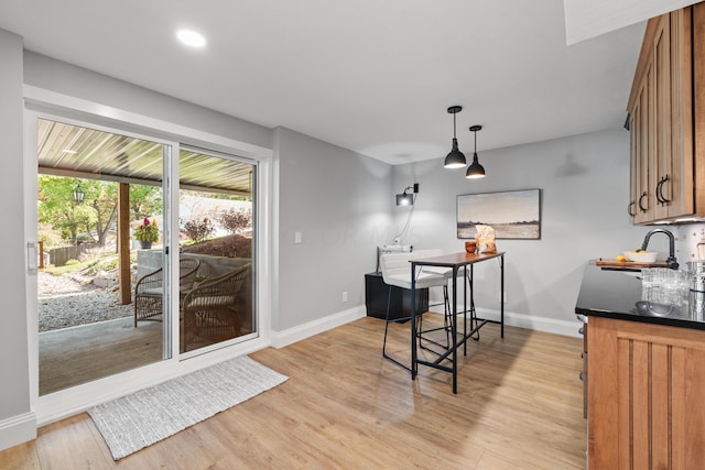 dining space with sink and light hardwood / wood-style flooring