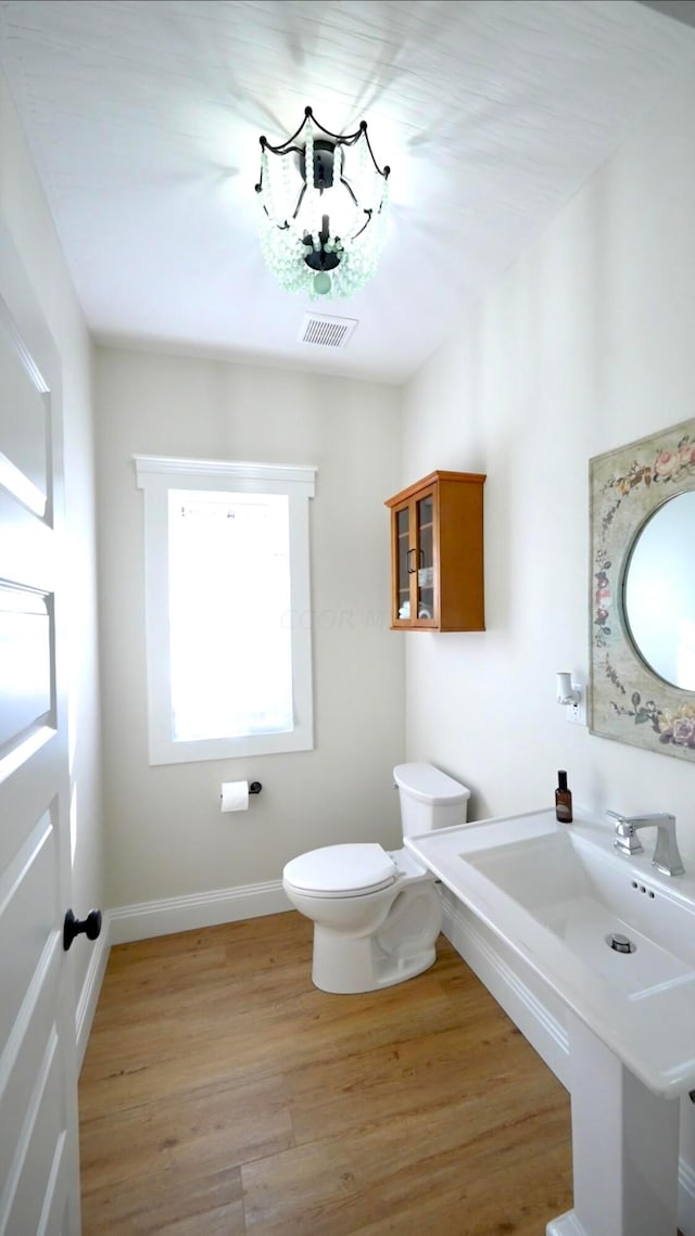 bathroom with hardwood / wood-style flooring and toilet